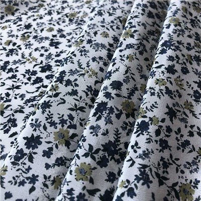 Crepe De Chine s modrými kvetmi na bielej látke